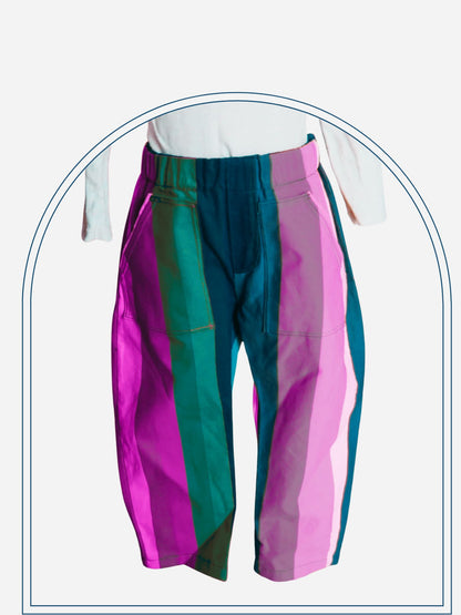 Rainbow striped pants worn by a person against a neutral background