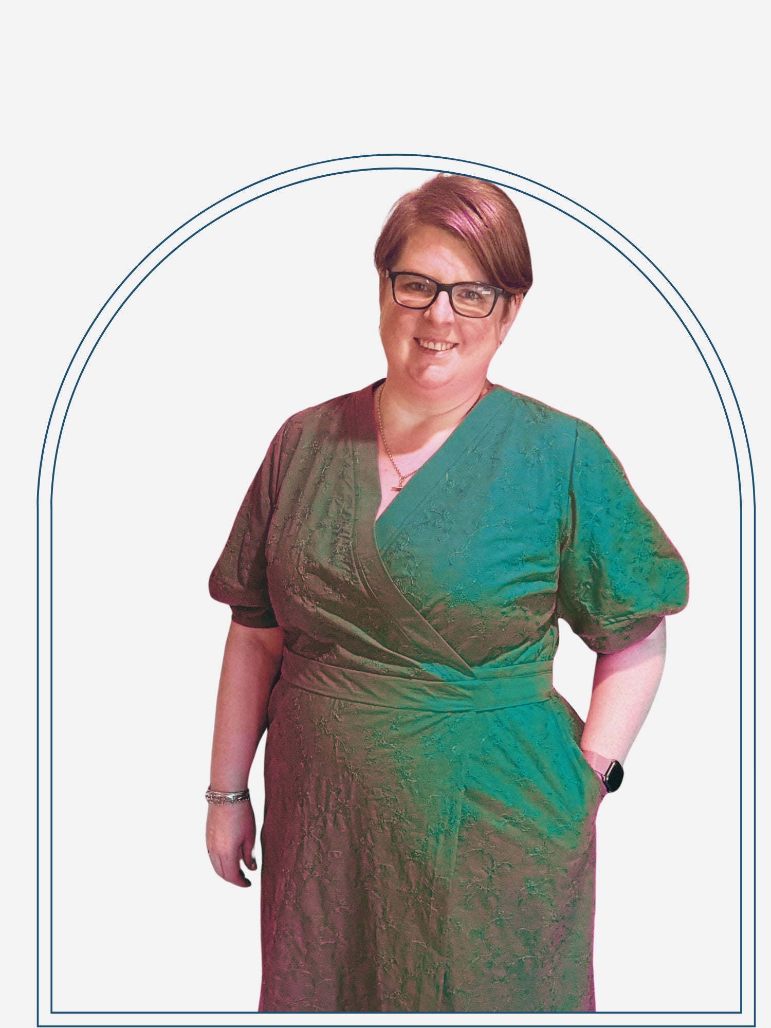 Woman wearing a pink dress standing indoors with a decorative wall in the background