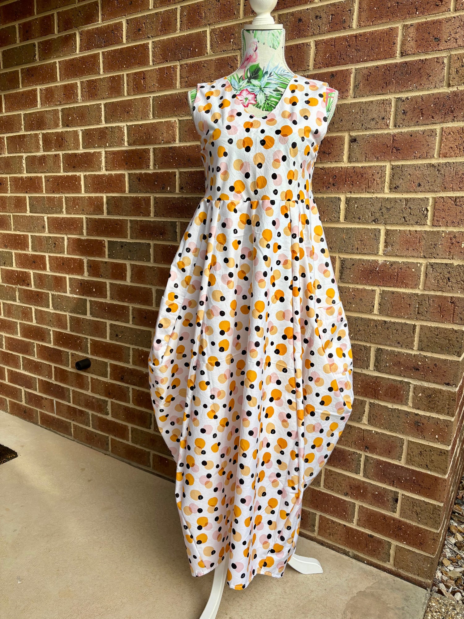 Spots dress on a mannequin against a brick wall