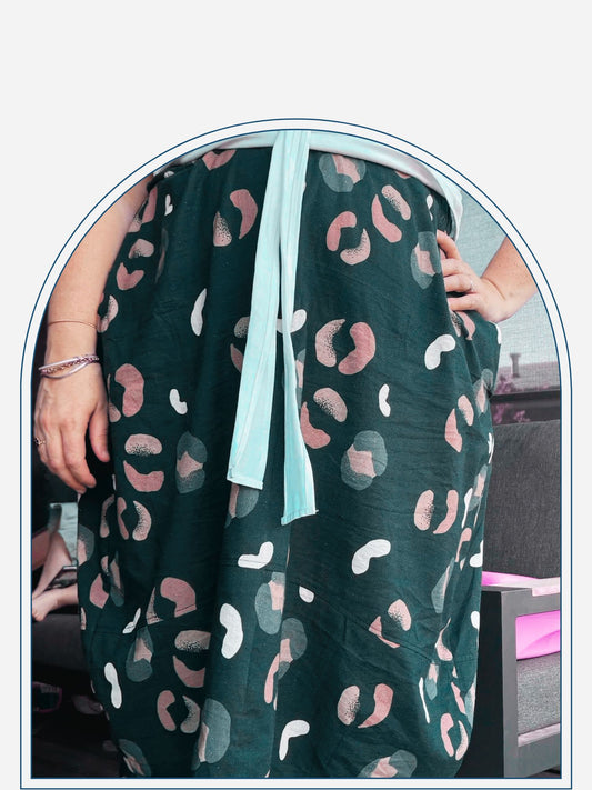 Person wearing a navy skirt with pink and green abstract patterns on a wooden deck.